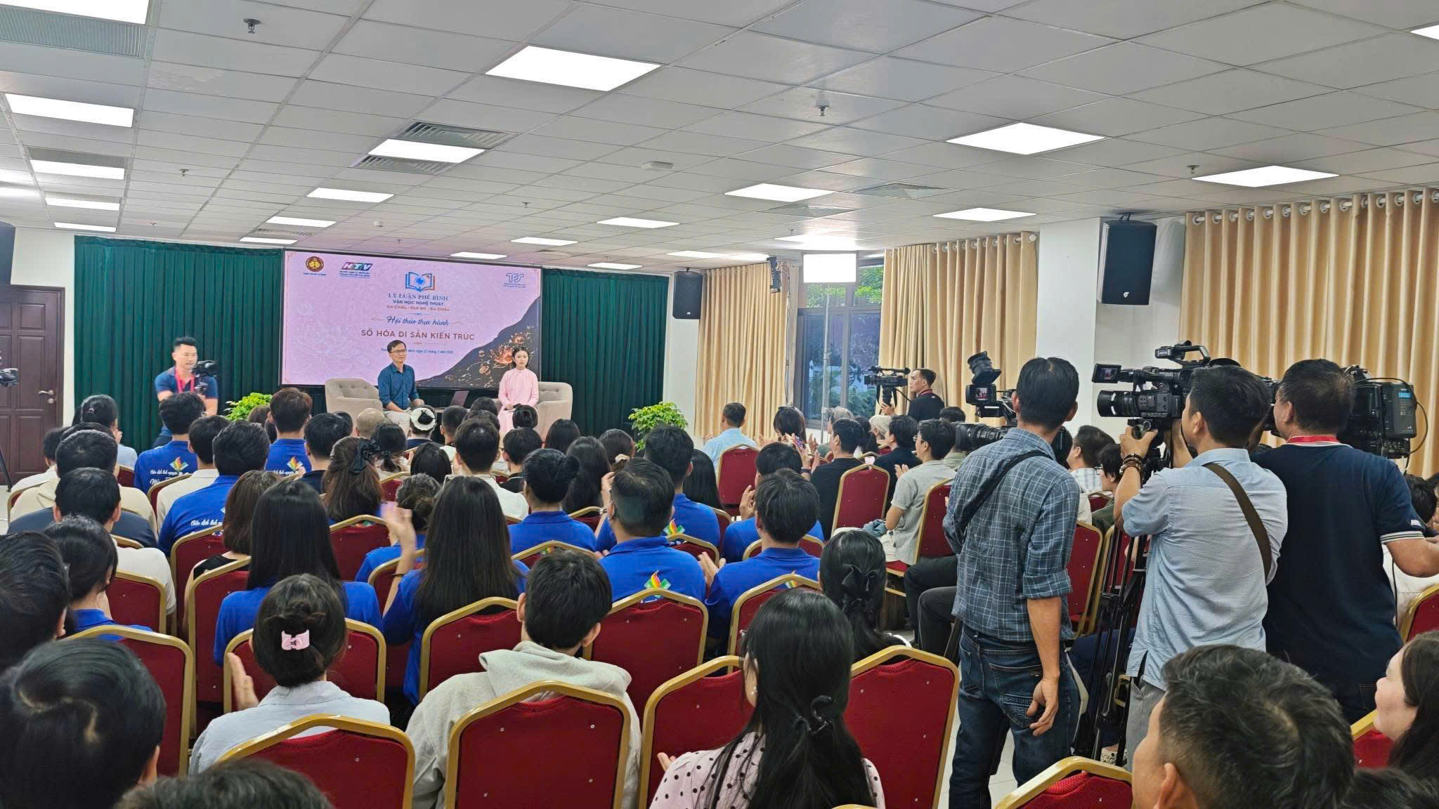 Khán phòng đông người tham dự hội thảo Số hóa di sản kiến trúc tại Bảo tàng Tôn Đức Thắng, ê-kíp HTV quay phim ghi hình sự kiện